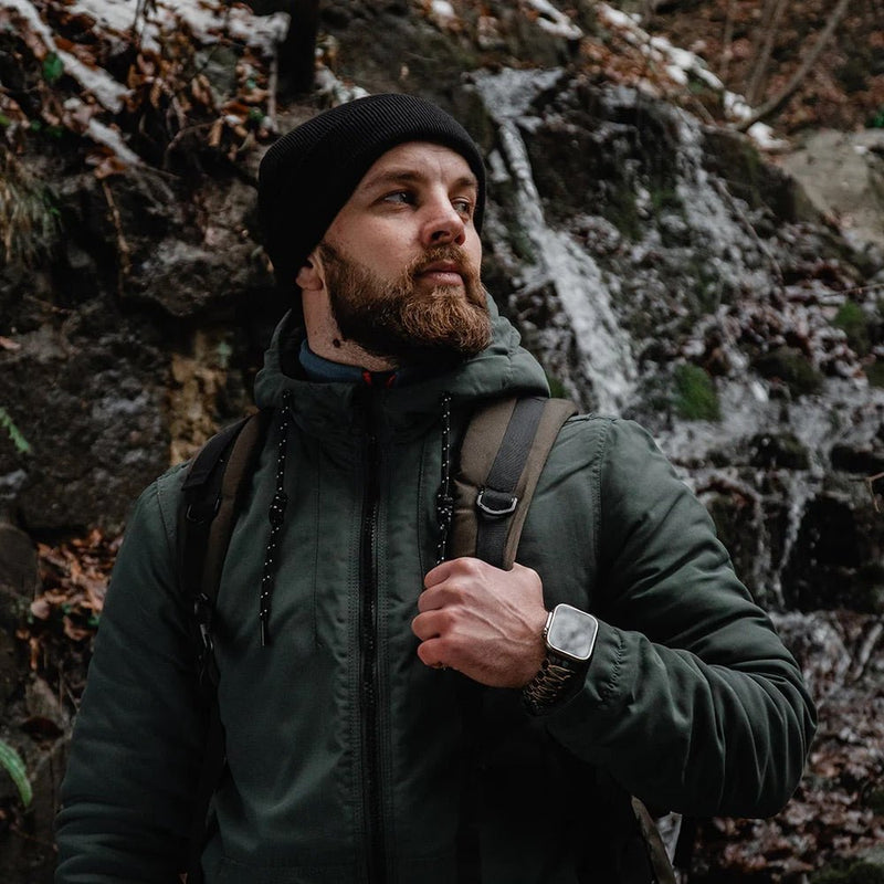 Bracelet paracorde noir ajustable SURVIVOR et EXPLORATEUR pour Apple Watch porté en extérieur sur poignet homme.