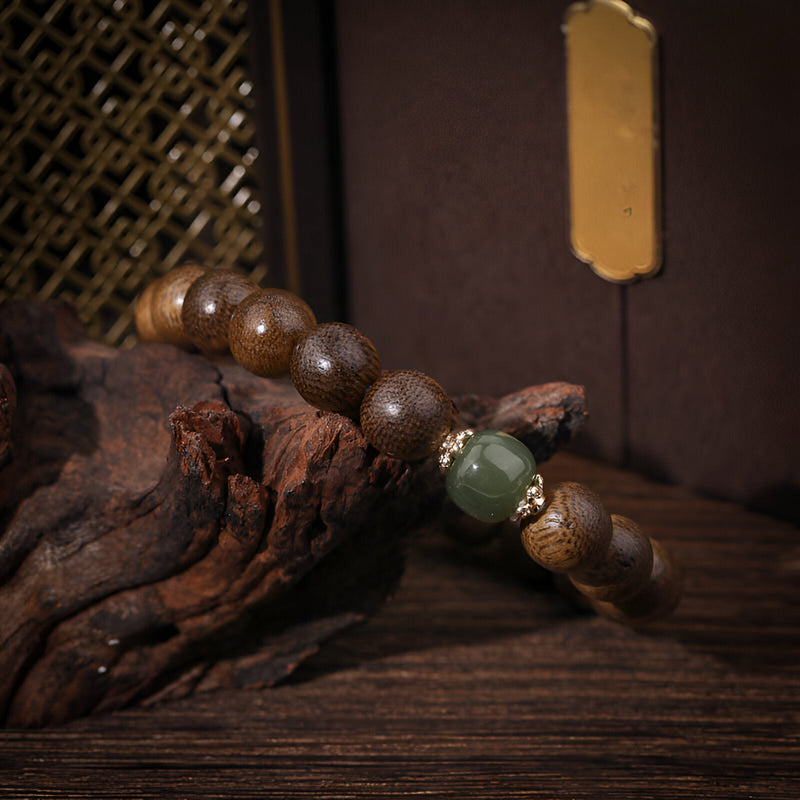 Bracelet femme en perles de bois d'agar marron avec perles en verre vert et dorées, style naturel et élégant.
