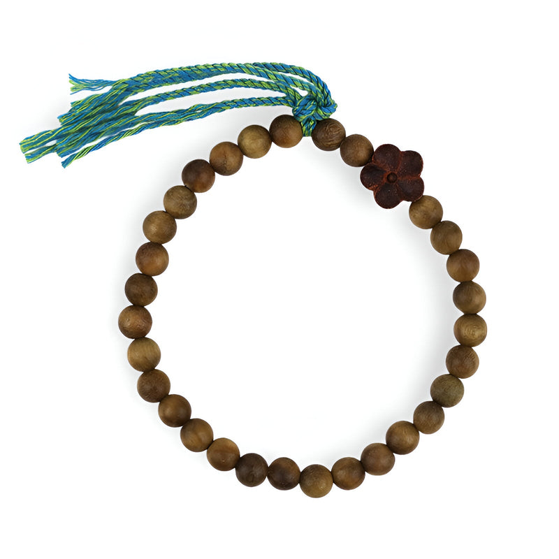 Bracelet en perles rondes marron en bois de santal avec ornement floral et cordon tressé bleu et vert.