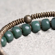 Bracelet femme en perles vertes et rondelles cuivre, perle centrale texturée acier vieilli.