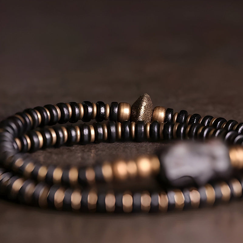 Bracelet double tour en perles de bois d'ébène noir et accents en cuivre, style moderne et élégant.