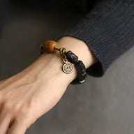 Bracelet femme en perles de bois d'ébène noir, détail cuivre spirale, pierre de jade verte.