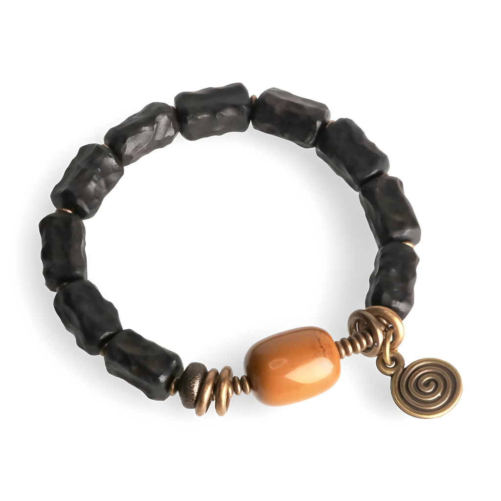 Bracelet féminin en perles noires d'ébène, pierre de jade ocre, accents cuivre spirale et anneaux.