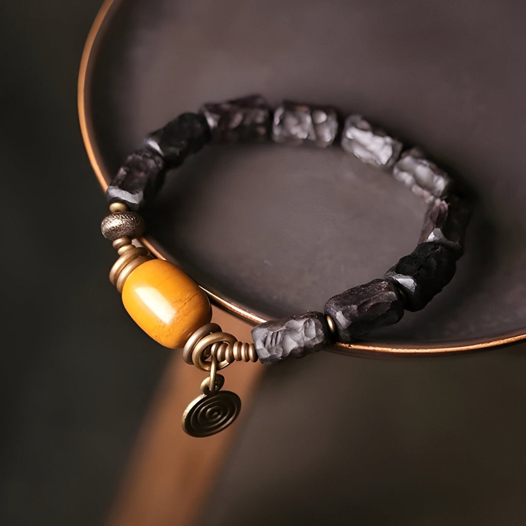 Bracelet femme en perles de bois d’ébène noir avec pierre de jade jaune et décor cuivre spiralé.