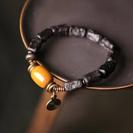 Bracelet femme en perles de bois d’ébène noir avec pierre de jade jaune et décor cuivre spiralé.