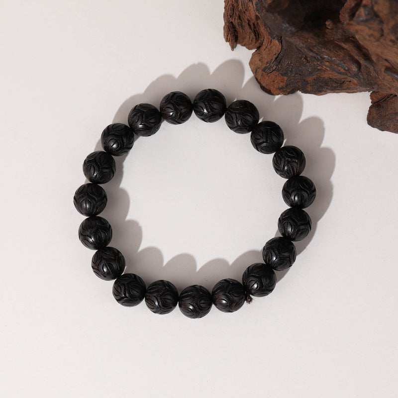 Bracelet élastique en perles rondes de bois d’ébène noir texturé uniforme.