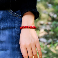 Bracelet mixte en perles de bois rouge, modèle Solal, porté au poignet, style casual.