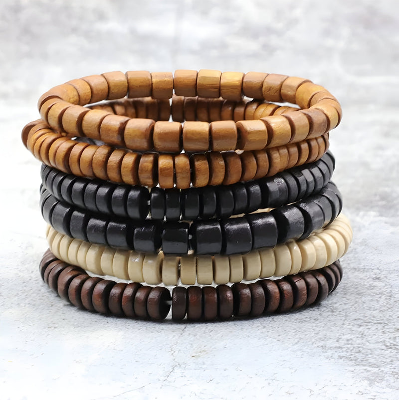 Quatre bracelets empilés en perles de bois avec couleurs marron clair, noir, beige et marron foncé.