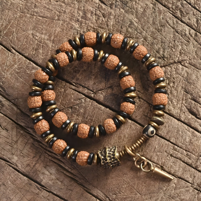 Bracelet femme en perles de Rudraksha marron et bois d'ébène noir avec breloques cuivre et fermoir boucle.