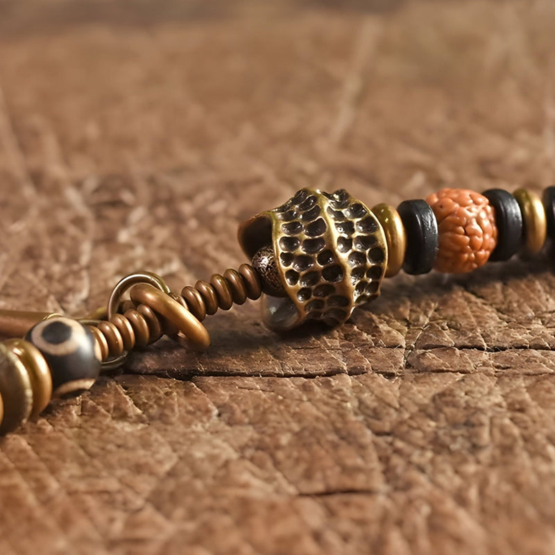 Bracelet femme perles de Rudraksha marron et bois d'ébène avec détail en métal cuivré texturé.
