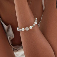 Bracelet ajustable pour femme en perles d'eau douce blanches et grises, style élégant et naturel.