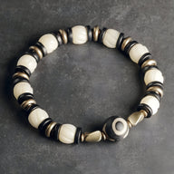 Bracelet femme en perles blanches d'os de yak et bois d'ébène noir avec perle centrale décorée.