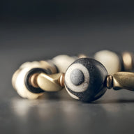 Bracelet femme à perles d'os de yak blanches et bois d'ébène noir avec motifs ronds blancs.