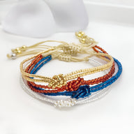 Bracelets en perles du Japon avec nœud central, couleurs or, bleu, rouge et blanc, style tissé finement.