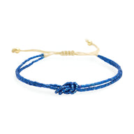 Bracelet bleu en perles japonaises avec nœud central et cordon beige réglable.