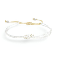 Bracelet femme perles blanches Japon avec nœud central doré et cordon ajustable beige.