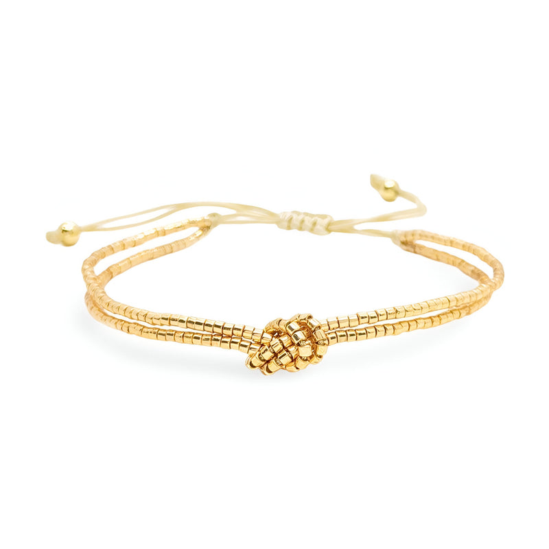 Bracelet femme or en perles du Japon à nœud central tressé et lien réglable.