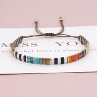 Bracelet ajustable en perles japonaises multicolores avec cordon marron et fermoir coulissant.