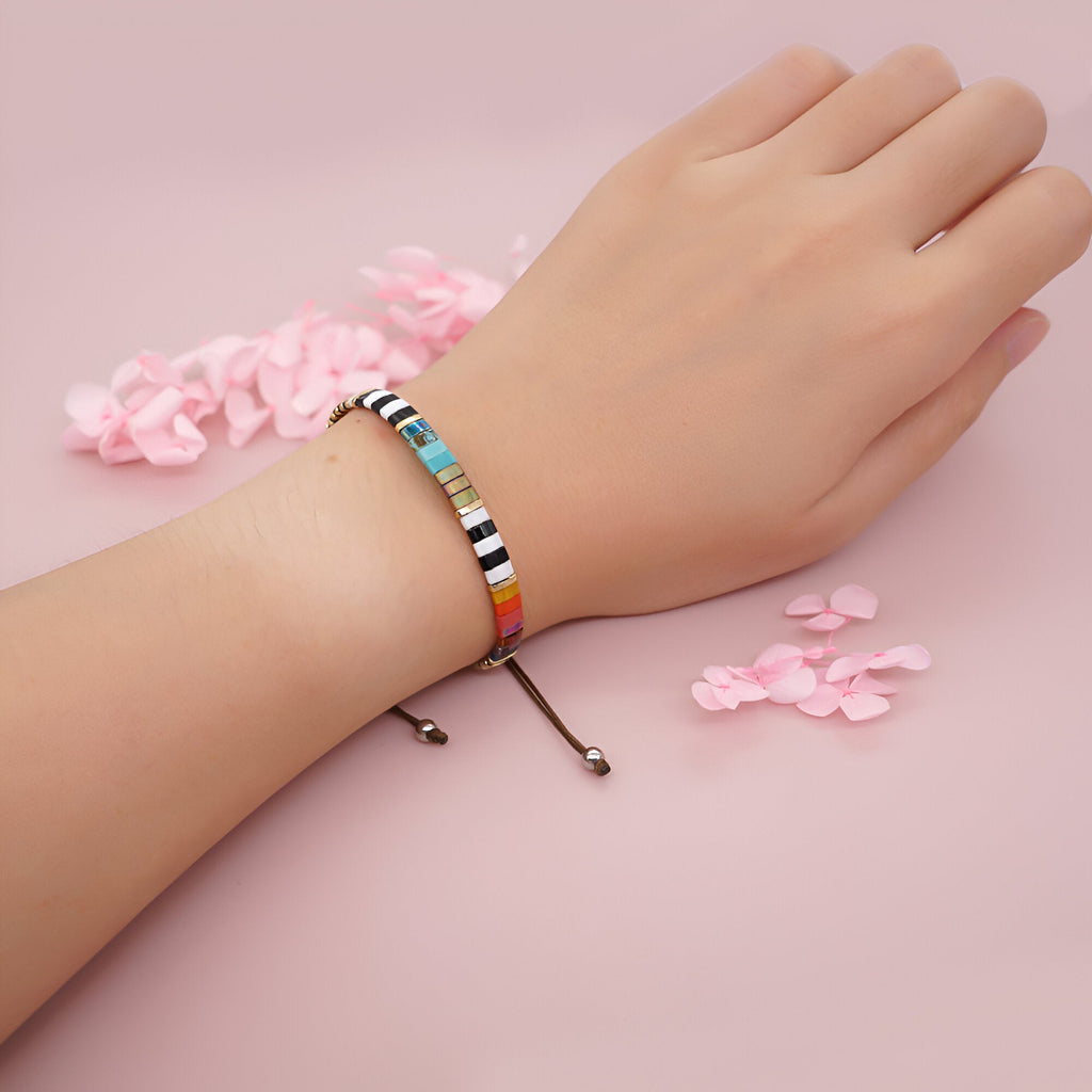 Bracelet ajustable en perles multicolores du Japon sur poignet, style moderne et élégant.