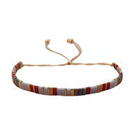 Bracelet en perles japonaises couleurs terre, ajustable avec cordon beige, style tissé fin.