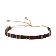 Bracelet ajustable en perles japonaises noires, rouges et dorées avec cordon beige.