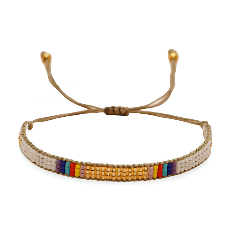 Bracelet ajustable en perles rondes blanches, or et multicolores sur fil beige.