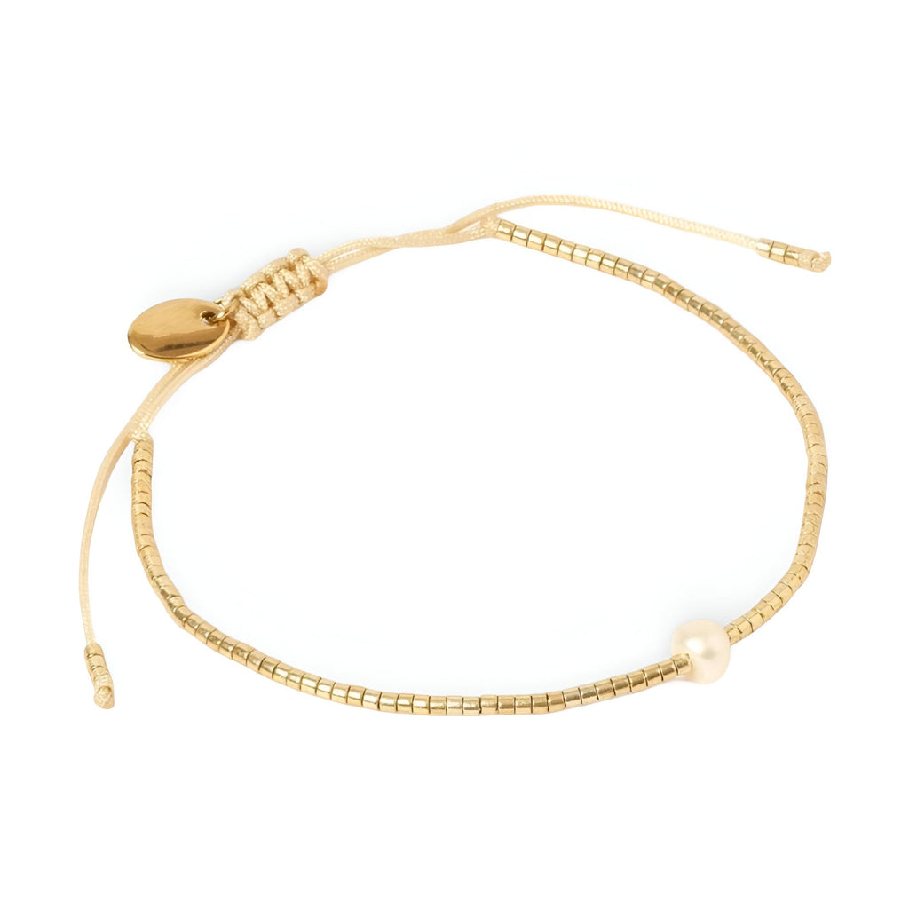 Bracelet délicat en perles dorées japonaises avec une perle blanche unique et fermoir doré ajustable.