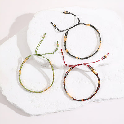 Trois bracelets double-rangs en perles du Japon, ajustables, en beige, vert et bordeaux, détails noirs et dorés.
