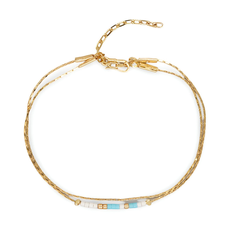 Bracelet double-rangs en perles bleu clair et blanc avec chaînette dorée élégante.