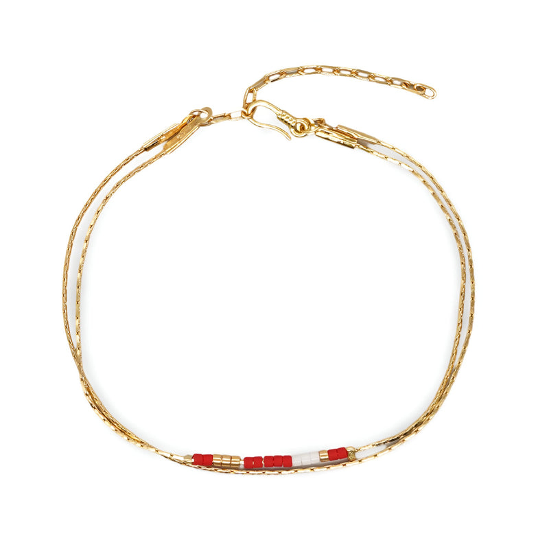 Bracelet double-rangs en perles rouges et blanches avec chaîne dorée réglable.