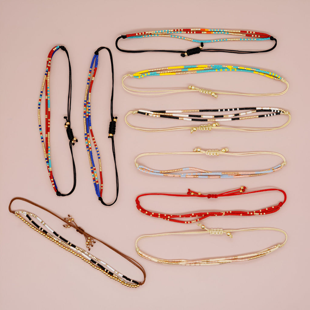 Bracelets multi-rangs en perles colorées et fines chaînes dorées, styles variés, inspiration japonaise élégante.