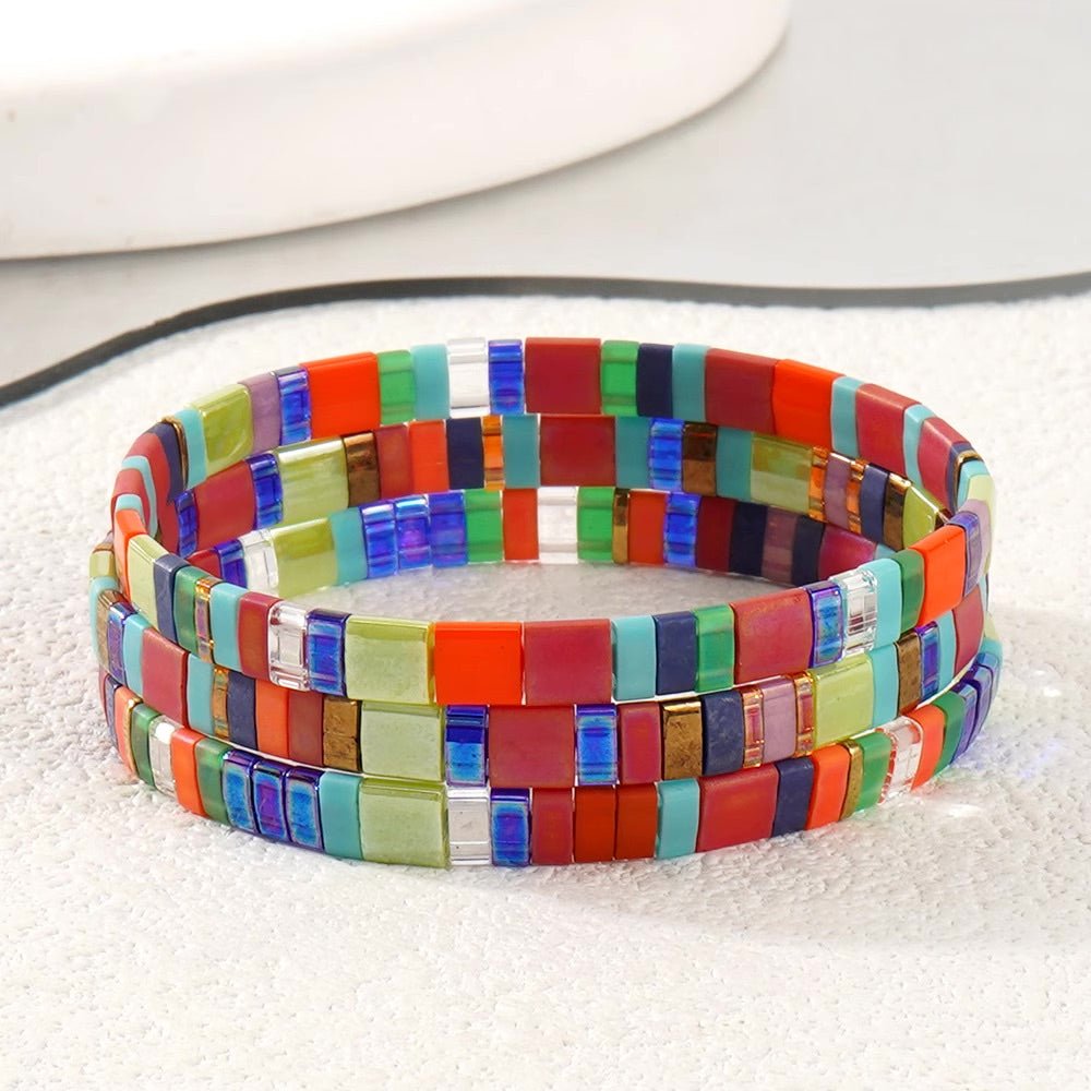 Bracelet en perles carrées multicolores rouge, vert, bleu et or, style spirale pour femme.