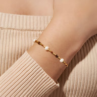 Bracelet femme en perles japonaises beiges et pierres de grès marron sur fil doré.