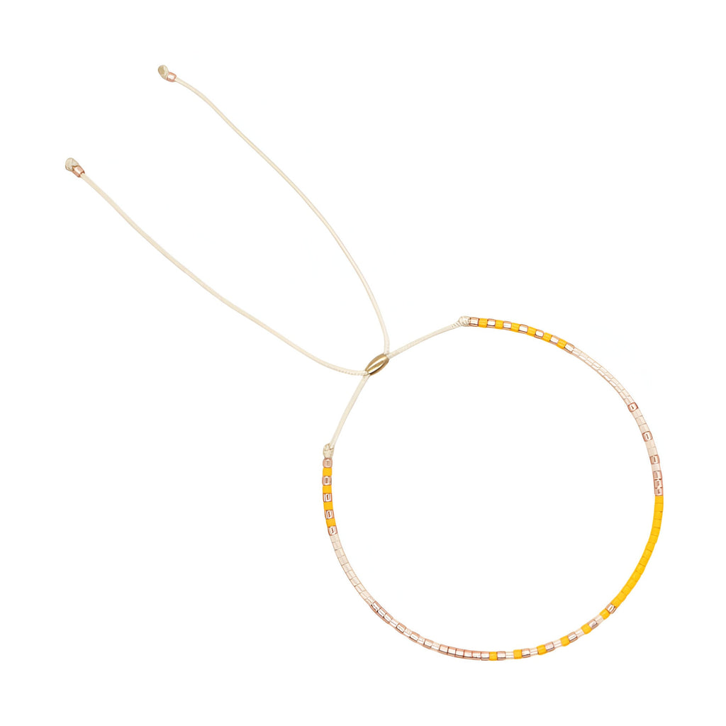 Bracelet ajustable en perles japonaises jaunes et blanches avec fil doré fin.