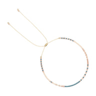 Bracelet fin avec petites perles turquoise et pêche alternées sur fil beige ajustable.