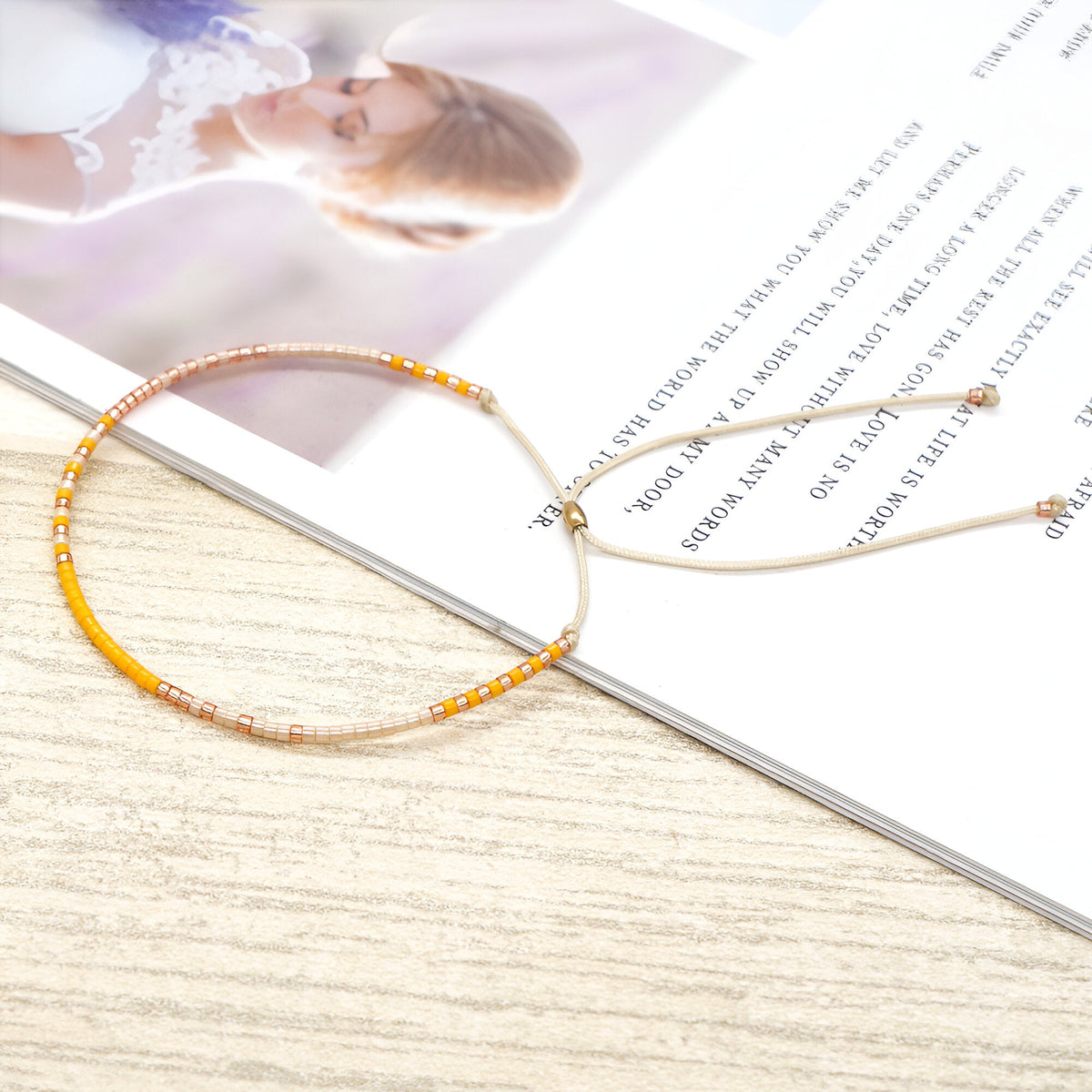 Bracelet en perles japonaises fines dégradé orange et beige avec fermoir coulissant or rose.