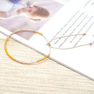 Bracelet en perles japonaises fines dégradé orange et beige avec fermoir coulissant or rose.