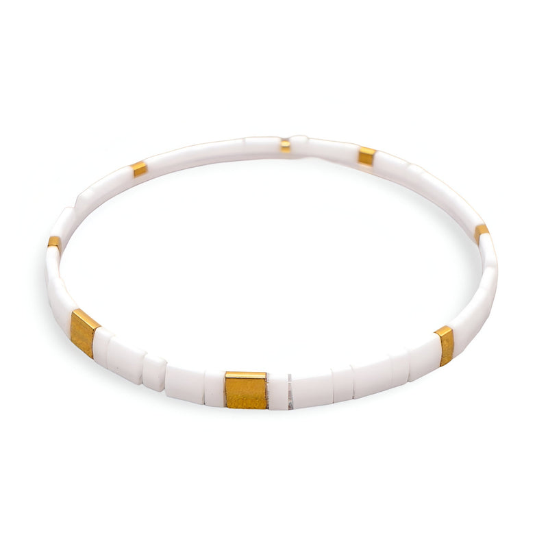 Bracelet fin en perles blanches et dorées, design minimaliste et élégant pour femme.