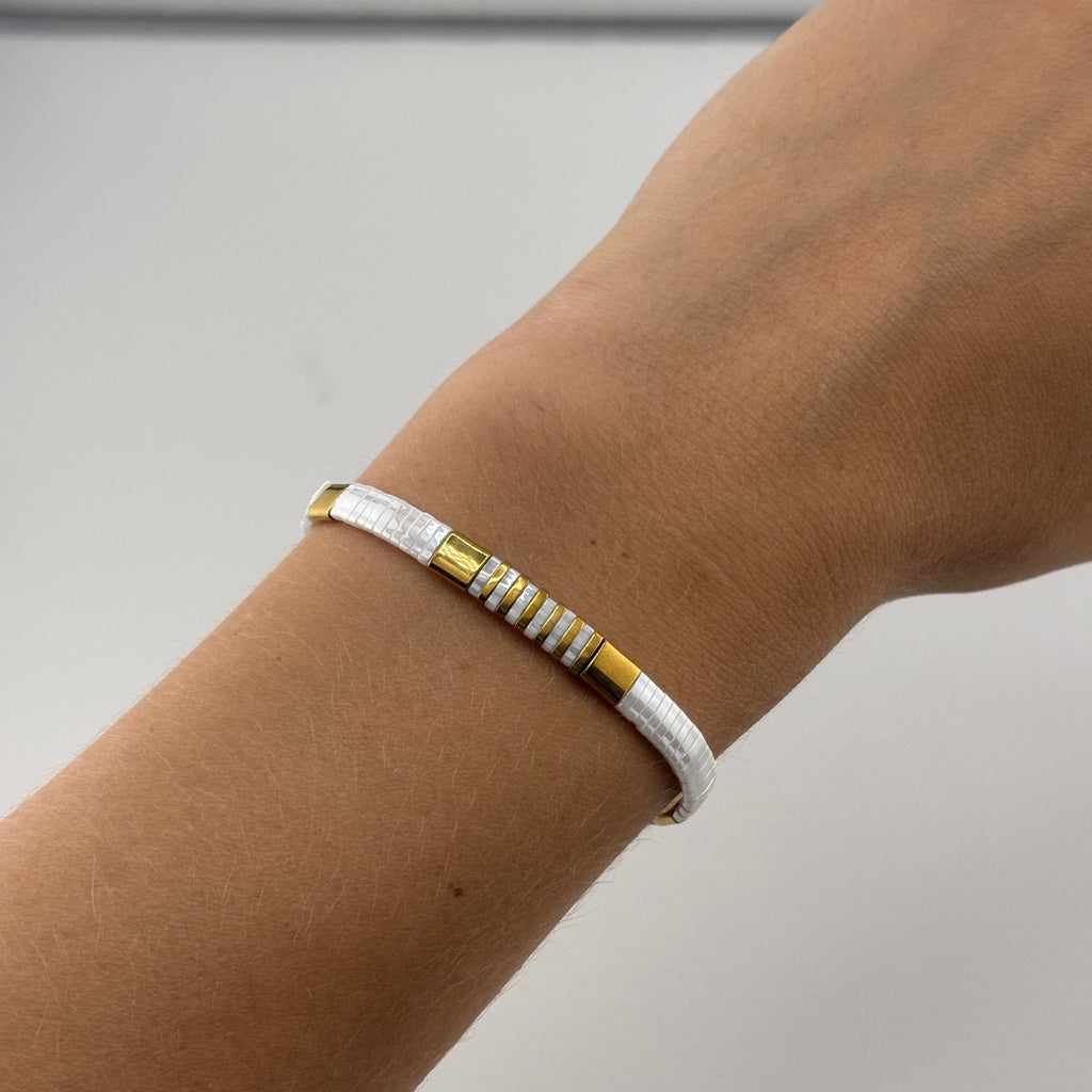 Bracelet femme perles blanches et jaunes motif géométrique, style minimaliste.