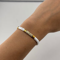 Bracelet femme perles blanches et jaunes motif géométrique, style minimaliste.