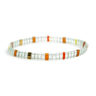 Bracelet féminin en perles japonaises blanches avec accents orange, rouge et vert, motif géométrique délicat.