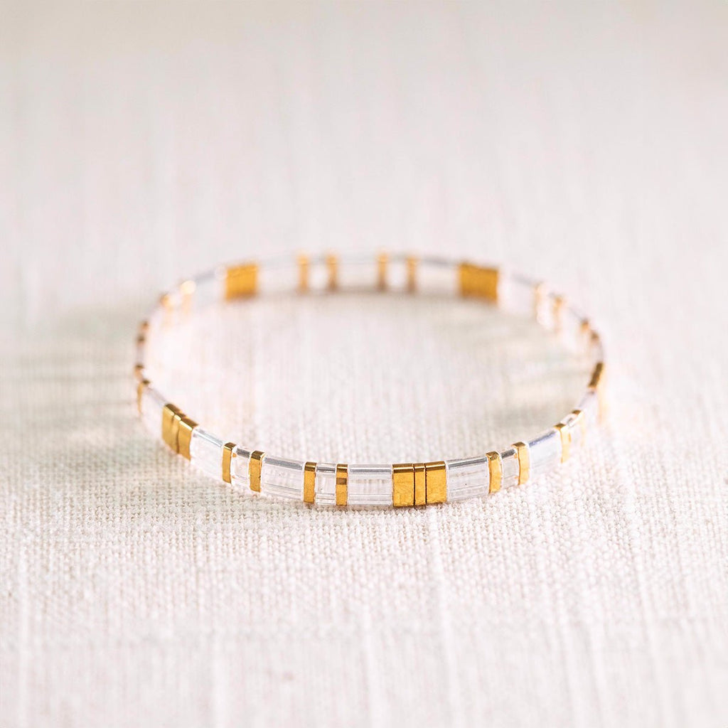 Bracelet femme en perles transparentes et dorées, style Kilua élégant et minimaliste.