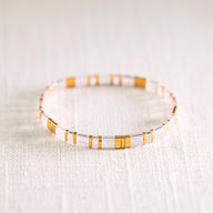 Bracelet femme en perles transparentes et dorées, style Kilua élégant et minimaliste.