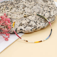 Bracelet fin en perles de verre multicolores, style Kumiko, fermoir doré ajustable.