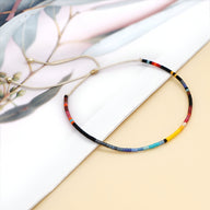 Bracelet fin en perles colorées multicolores style Kumiko sur fond clair.