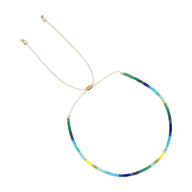 Bracelet fin en perles japonaises multicolores avec fermoir coulissant doré pour femme.