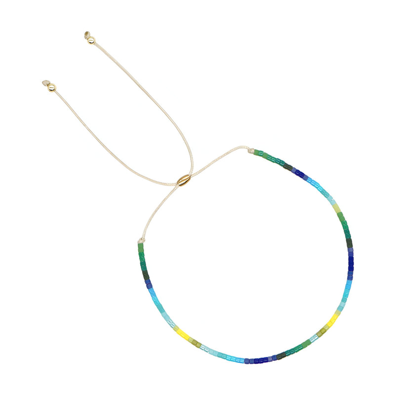 Bracelet fin en perles japonaises multicolores avec fermoir coulissant doré pour femme.