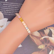 Bracelet femme perles carrées rose, blanc et or, style minimaliste et contemporain.