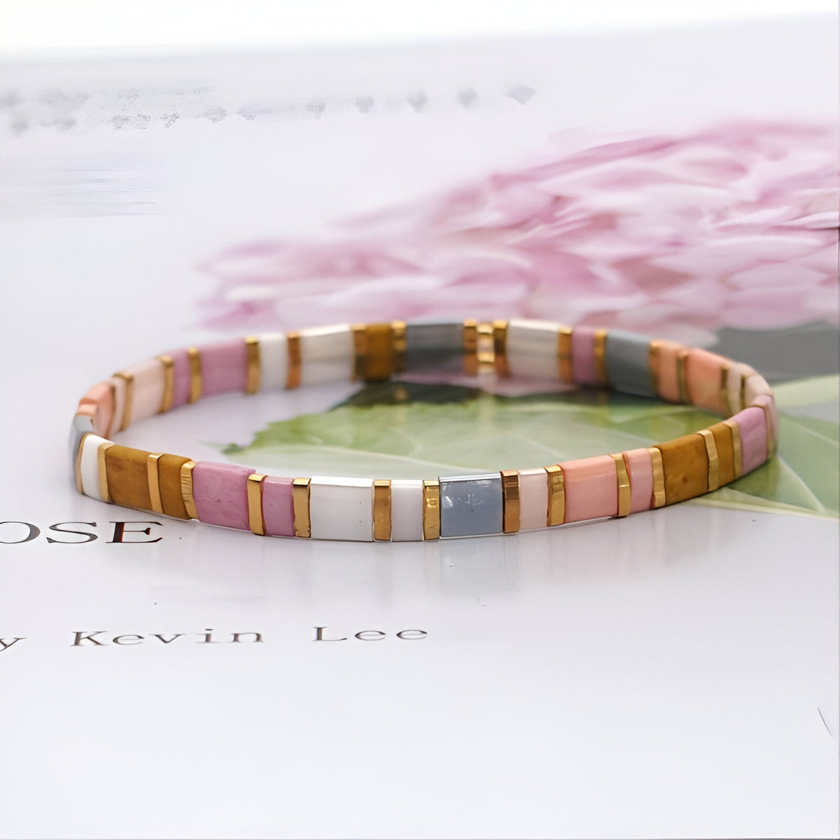 Bracelet femme en perles plates couleur rose, blanc, beige et gris, style moderne et élégant.