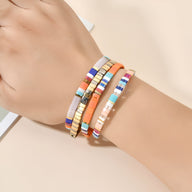 Bracelet en perles multicolores fines avec détails dorés, style élégant et moderne pour femme.